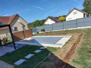 Photo de galerie - Chantier de pose de traverse paysagère autour d'une piscine. Une alternative plus organique à la pose de bordures en béton. 