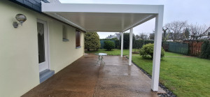 Photo de galerie - Installation d’une pergola aluminium adossée sur mesure. Structure robuste, fixation soignée et finitions précises pour une protection efficace et durable, apportant confort et esthétique à votre terrasse.