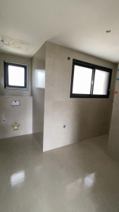 Photo de galerie - Réalisation d’un carrelage grand format 120 × 120 cm, avec une pose soignée et un alignement précis. Les finitions sont réalisées avec des angles en biseau, pour un rendu moderne, propre et haut de gamme.