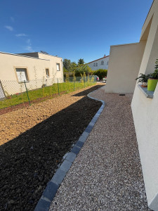 Photo de galerie - Réfection complète d’un jardin, du gazon avec un cheminement en gravier et bordure pavées.