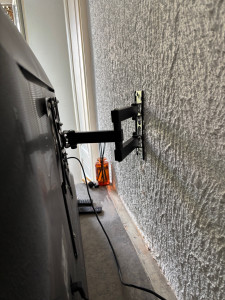 Photo de galerie - Installation d’un bras articulé pour téléviseur, fixée solidement au mur. Travail précis et propre pour un rendu esthétique et sécuris
