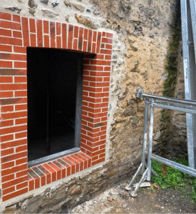 Photo de galerie - Ouverture faite dans un mur avec un encadrement en brique une légère voûte et des jambages en briques
