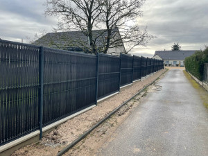 Photo de galerie - Réalisation d’une clôture en panneau rigide avec plaque de soubassement, avec finition en lame composite 