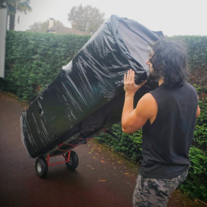 Photo de galerie - Port et déplacement d’un frigo emballé avec diable, protections adaptées et manutention sécurisée