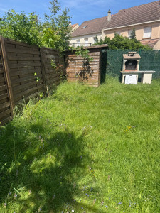 Photo de galerie - Remise en état complète d'un jardin avec herbes hautes. Tonte précise, passage de la débroussailleuse sur les bordures et évacuation des déchets verts pour un résultat impeccable.