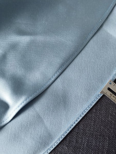 Photo de galerie - Mini ourlet à la machine sur une robe en satin. Dans la photo vous voyez les deux faces, pour apprécier la discrétion et précision du travail.
Note: le prix d'un ourlet est variable en fonction du longueur de tissu à coudre et la technique utilisée.