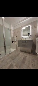 Photo de galerie - Remplacement d'une baignoire en fonte par une douche à l'italienne PMR, sans faïence à faire, revêtement en plaque antibactérienne. Remplacement meuble vasque et miroir. Sol en PVC.