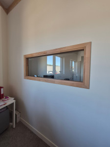Photo de galerie - Pose d’un châssis vitré intérieur en bois. Mise en place, réglage et ajustement du châssis pour une intégration propre dans la cloison.