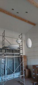 Photo de galerie - Installation d’un luminaire composé de trois suspensions design aux formes et volumes différents, fixées individuellement au plafond pour créer un ensemble harmonieux et moderne.