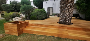 Photo de galerie - Une terrasse en bois exotique garapa de 80m2 avec sa jardinière incorporée et son escalier