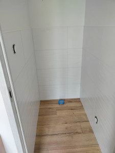 Photo de galerie - 
pose de faïence et de parquet dans un toilette. 