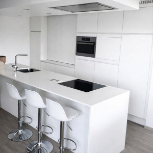 Photo de galerie - Création et pose d’une cuisine moderne sur mesure. Installation de l’îlot central avec plaque induction et évier intégré, pose du four encastré et des meubles toute hauteur. Finitions soignées, alignements précis et rendu contemporain haut de gamme.