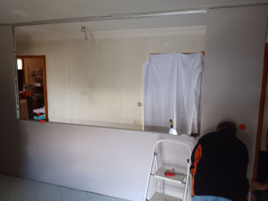 Photo de galerie - Remontage du mur avec ouverture et installation d'étagère en bois en cours 