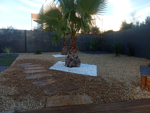 Photo de galerie - Réalisation terminée client satisfait superbe décoration gravier nacré roulé de rivière et anthracite avec chemin de pierre de schiste.