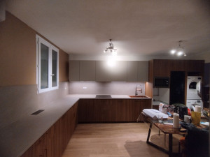 Photo de galerie - Pose d'une cuisine d'angle, avec colonne four et micro-ondes, meubles hauts, Led, évier, plaque et prise encastrée.