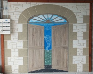 Photo de galerie - Ragréage mural extérieur - Arche et mur de pierres en enduit gresé taloché - Portes et imposte en lame de sol PVC à coller - Sol en ardoise - Paysage en peinture acrylique extérieure