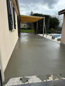Photo de galerie - Réalisation d’une terrasse béton avec pente de 2% pour évacuation des eaux de pluie dans un caniveau