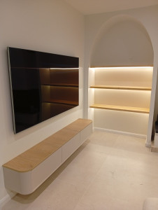 Photo de galerie - TV sur support mural extra plat & passage câbles non apparent / meuble suspendu / niche avec arche & étagères à fixations invisibles & LED commande à induction 