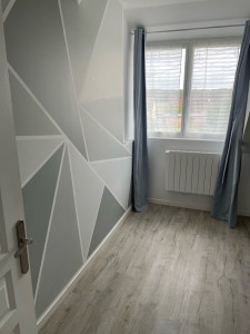 Photo de galerie - Travaux de peinture dans une chambre avec réalisation de motifs  triangulaires avec différentes nuances de gris 