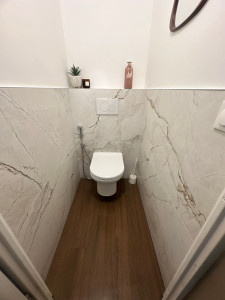 Photo de galerie - Réalisation d’un espace WC sur mesure avec carrelage effet marbre. Pose soignée, découpes précises et finitions propres.