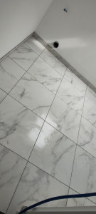 Photo de galerie - Pose d'une natte de désolidarisation sur plancher avec pose carrelage format 60/60+ plinthes et joints couleur gris perle 