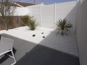 Photo de galerie - Reprise d'un massif très enherbé, mise en place d'une toile et gravier blanc pur avec végétaux.