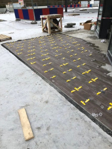 Photo de galerie - Pose de carrelage extérieur imitation bois avec système de nivellement pour une finition parfaitement alignée et durable.
