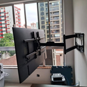 Photo de galerie - Fixation murale de TV grand format sur support articulé : installation solide, positionnement précis et rendu propre pour un confort de vision optimal.