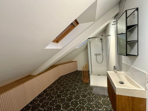 Photo de galerie - Rénovation salle d’eau sous combles. Étanchéité Schlüter sur plancher bois. Aménagement sur mesure optimisant l'espace sous pente. Pose de carrelage hexagonal et installation douche/vasque. Expertise technique en milieux atypiques.