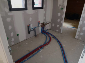 Photo de galerie - Installation des réseaux d’eau chaude et froide, pose des nourrices et des évacuations sanitaires