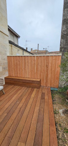 Photo de galerie - Terrasse bois exotique avec banc et habillage d'un mur avec du bardage bois exotique .
