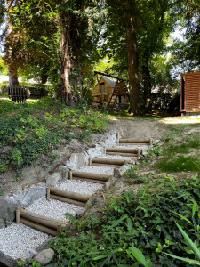 Photo de galerie - Création de marche d’escalier en rondin de bois avec petit muret de soutènement en pierre 
