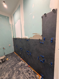 Photo de galerie - Pose de carrelage en 60/60cm sur tous les murs d’une salle de bain 