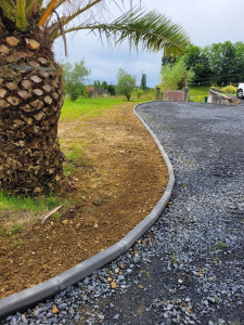 Photo de galerie - Pose de bordure béton anthracite, pour délimitation de l'allée et la pelouse avec des arrondis. 
