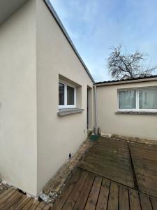 Photo de galerie - Façade entièrement rénovée avec une finition enduit gratté grain fin : rendu propre, uniforme et moderne, avec des contours de fenêtres nets et une teinte claire qui illumine l’extérieur.