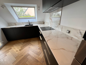 Photo de galerie - Parquet massif collé en bâtons rompus et pose d’une cuisine avec plan de travail en ceramique