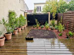 Photo de galerie - Aménagement du jardin : création d’espaces de plantation, haie en pots et massif arbustif paillé, nettoyage de la terrasse au karcher et préparation du sol pour un futur gazon.