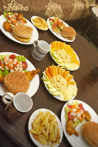 Photo de galerie - Préparation d'une jolie table festive avec de grands plateaux de fruits frais coupés et des accompagnements pour vos soirées et dîners entre amis