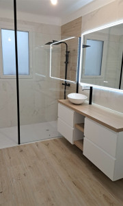 Photo de galerie - Salle de bain moderne avec douche à l'italienne, meuble vasque design et robinetterie noire.installation soigné et  fonctionnelle. 