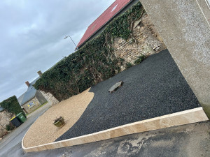 Photo de galerie - Création d’un massif avec bordure haute en travertin, et pose d’une bordure invisible pour deux modèles de gravillons 