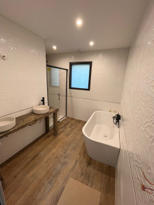Photo de galerie -  pose de carrelage sol/mur , installation de la baignoire ainsi que la douche 