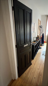 Photo de galerie - Modification de la porte vitrée existante : fermeture de la partie vitrée avec un panneau en bois afin de créer une porte pleine. Porte peint et changement de serrure 