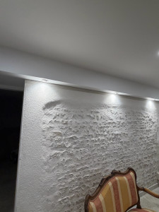 Photo de galerie - Installation de spots LED le long d’un mur en pierre apparente. Mise en valeur du relief avec éclairage soigné et sécurisé. 