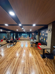 Photo de galerie - Projet de rénovation intérieure pour un restaurant : plafond design en bois, sol, éclairage et décoration. Résultat moderne, chaleureux et fonctionnel.