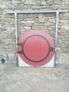 Photo de galerie - Porte ronde,de fabrication artisanale en mélange bois et métal de 1 m40 de diamètre avec l'encadrement près a scellé, pour jardin extérieur ou en décoration intérieure.