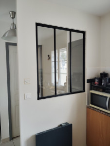 Photo de galerie - Pose d'une verrière noire en Aluminium sur cloison sèche pour apporter de la lumière dans une entrée de maison.
