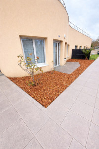 Photo de galerie - Aménagement d’un massif décoratif devant la maison : préparation du terrain, pose de toile géotextile pour limiter les mauvaises herbes et mise en place de paillage en copeaux de bois. Résultat propre, esthétique et facile d’entretien.