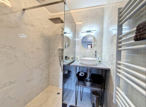 Photo de galerie - Salle de bain sur mesure (douche à l'italienne porte vitrée, vasque sur plan de travail, applique murale et sèche serviette 