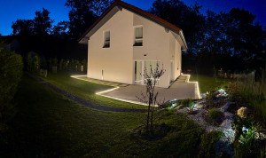 Photo de galerie - Aménagement paysager avec création de pelouse, cheminement en pas japonais et installation d’un éclairage extérieur LED autour de la terrasse.