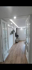 Photo de galerie - Rénovation complète d’un séjour : préparation et peinture des murs et plafonds, création d’un faux plafond avec éclairage LED indirect et spots encastrés, pose d’un parquet et réalisation des finitions.